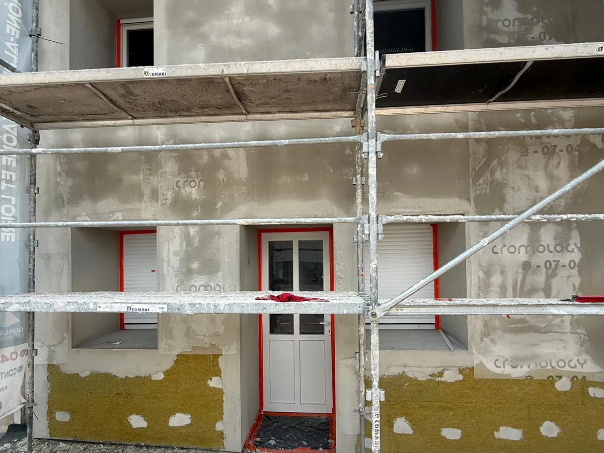 Pose de l'ITE en laine de roche par NFR à Bourg-en-Bresse, isolant et enduit de base sous échafaudage