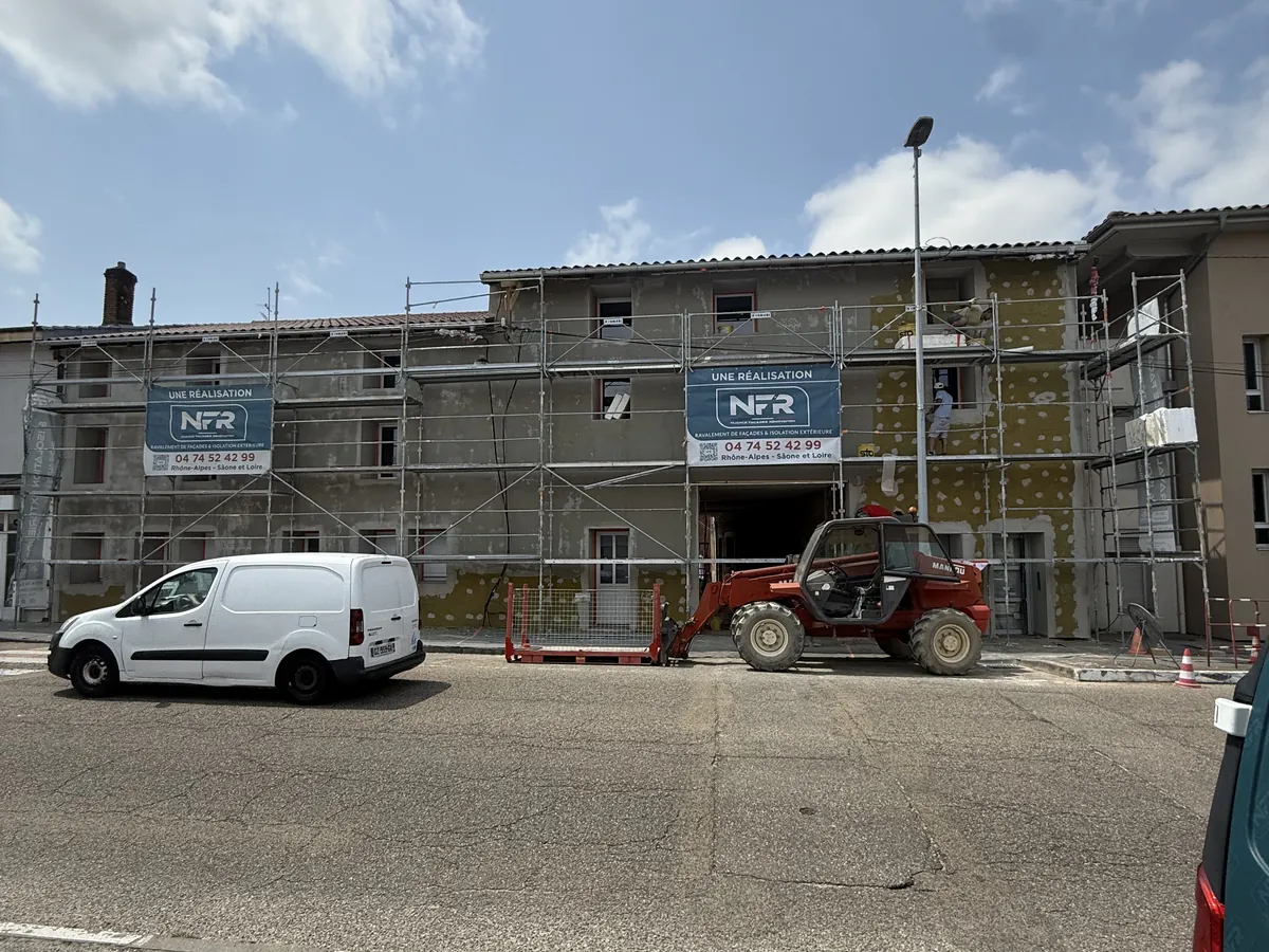 Chantier NFR d'isolation par l'extérieur en laine de roche à Bourg-en-Bresse : échafaudage et panneaux isolants en cours de pose