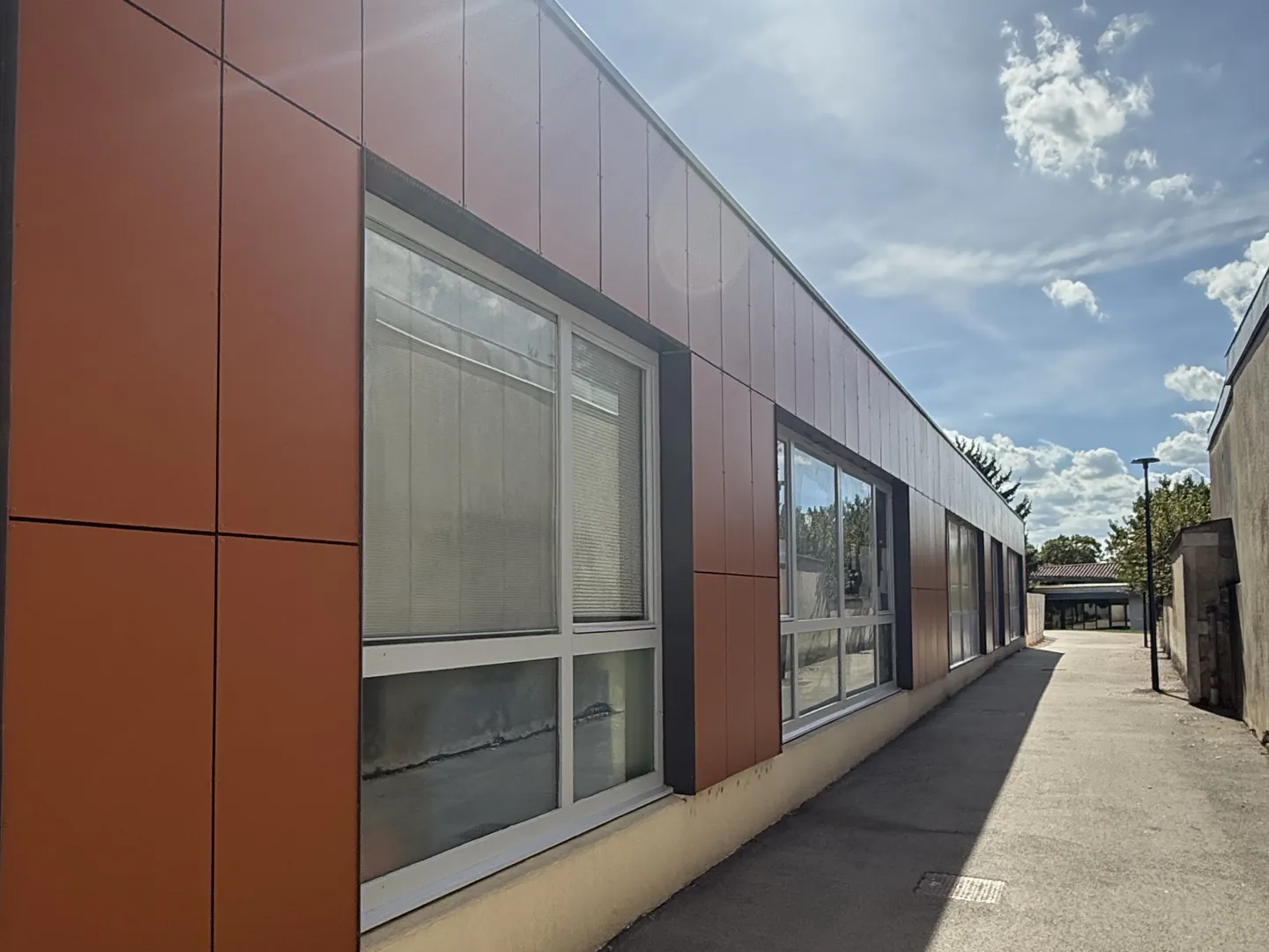 Après : le même mur avec le nouveau bardage ventilé posé par NFR, grands panneaux composite teinte terre cuite