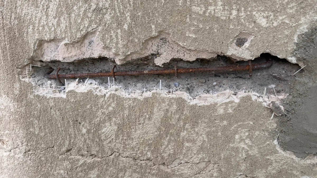 Fissure horizontale ouverte sur un mur à Beaupont, agrafe en acier scellée au fond de la saignée