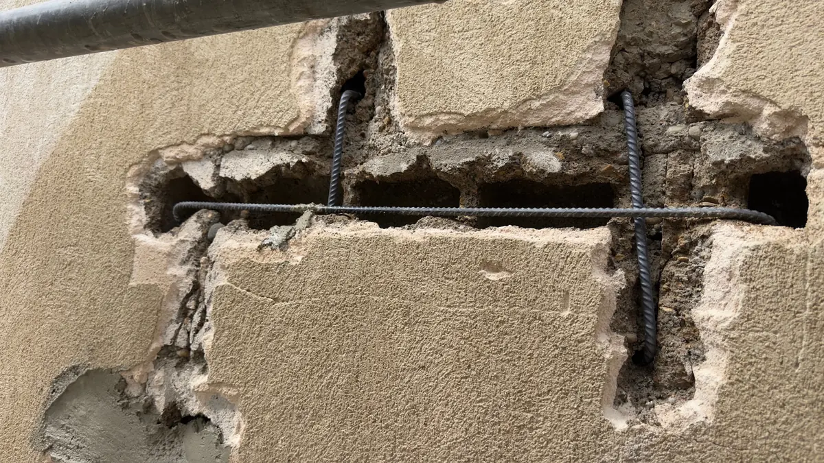 Fissure en escalier ouverte en tranchée et agrafée sur un pignon à Beaupont