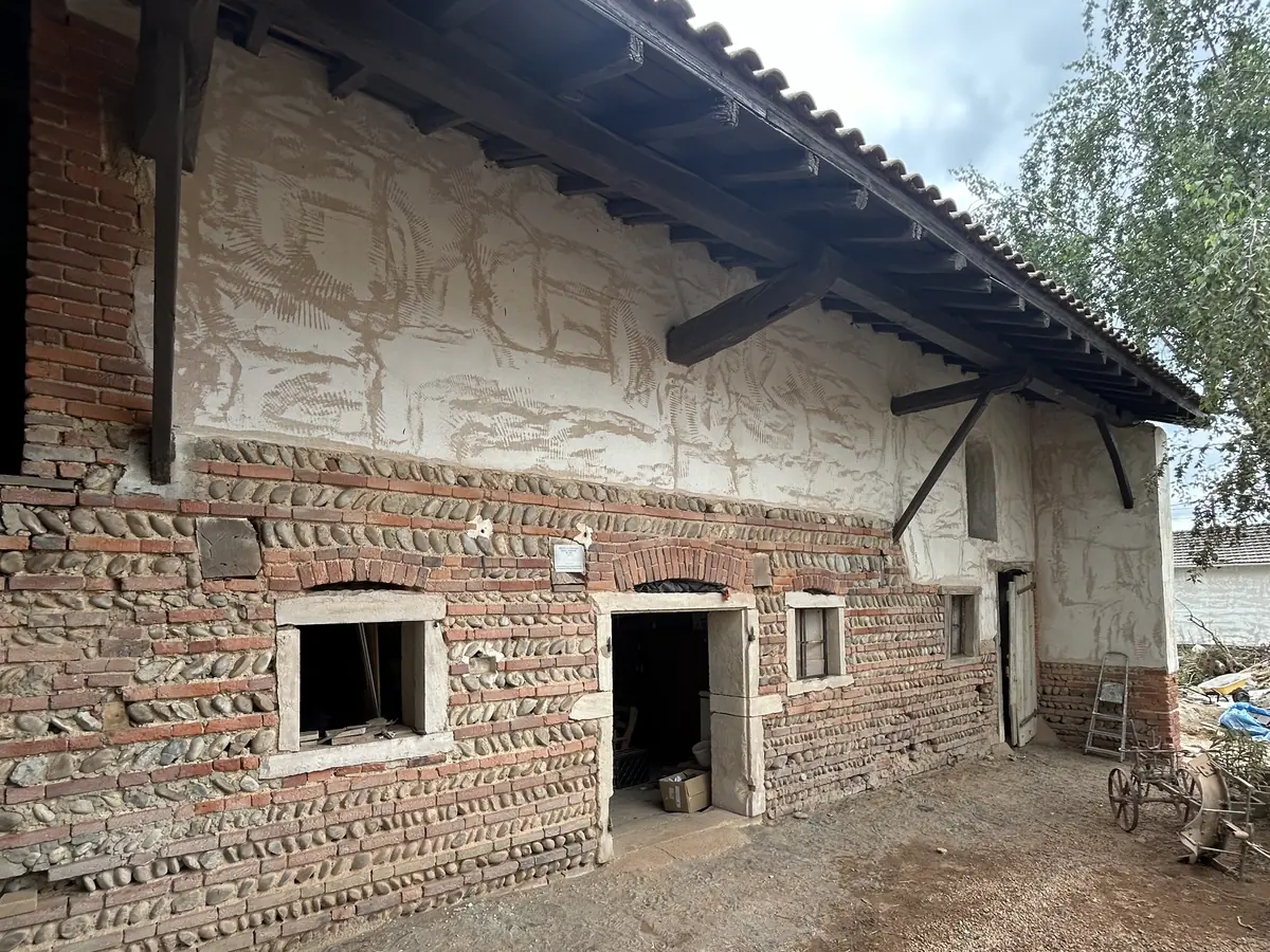 Mur de grange mêlant pisé et briques, enduit tombé, avant reprise