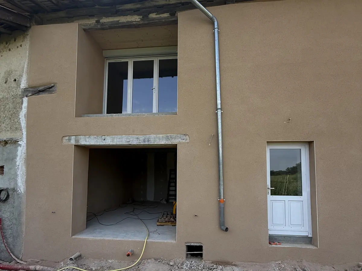Encadrement de fenêtre repris et sous-enduit frais sur une maison en pisé de la Dombes