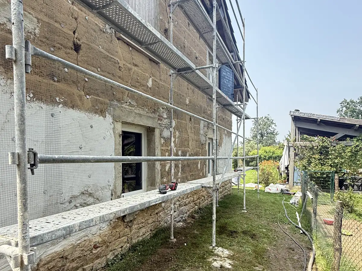 Mur ancien en pisé sous échafaudage à Sermoyer, reprise avant enduit