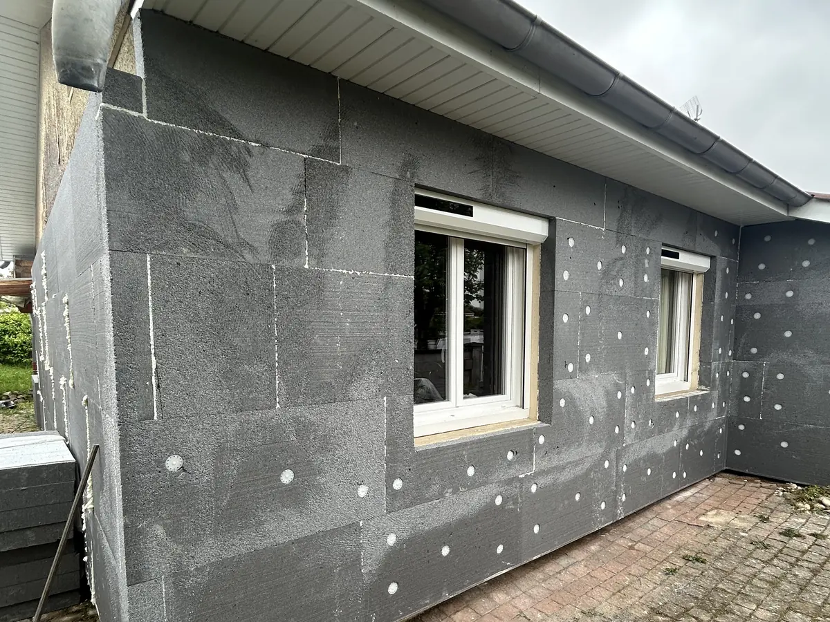 Maison à Villars-les-Dombes, panneaux isolants gris fixés autour des fenêtres avant sous-enduit