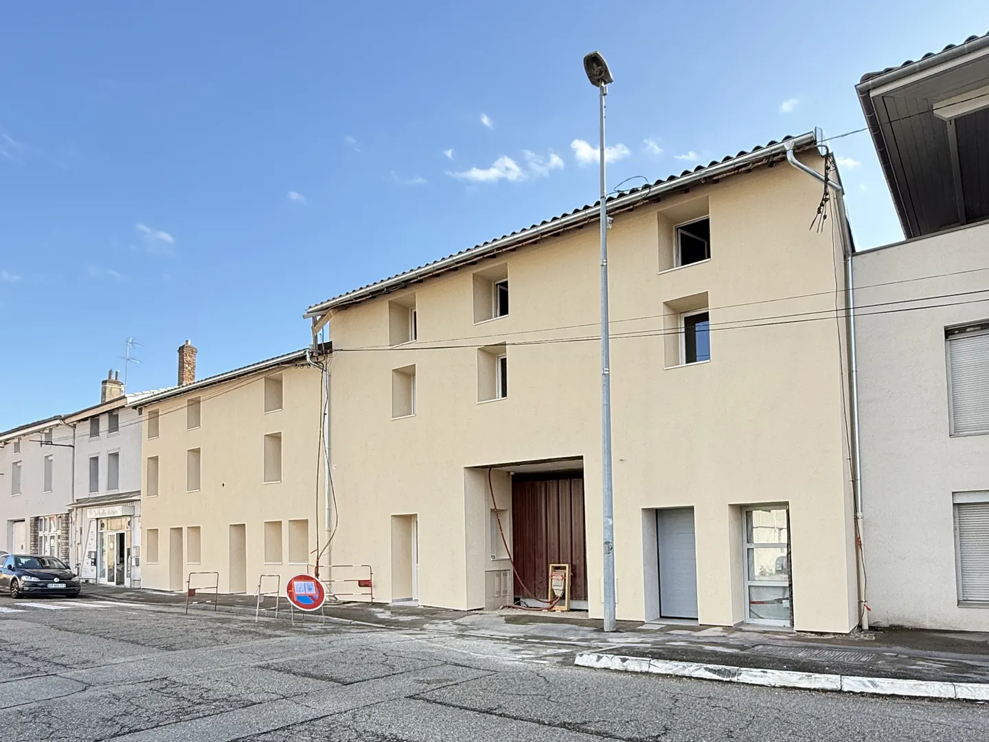 Vue de biais de la façade isolée par l'extérieur par NFR à Bourg-en-Bresse, enduit beige clair