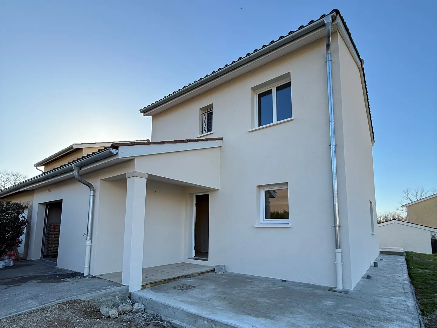 Façade d'entrée de la maison ravalée par NFR à Ceyzériat, enduit blanc et auvent sur piliers