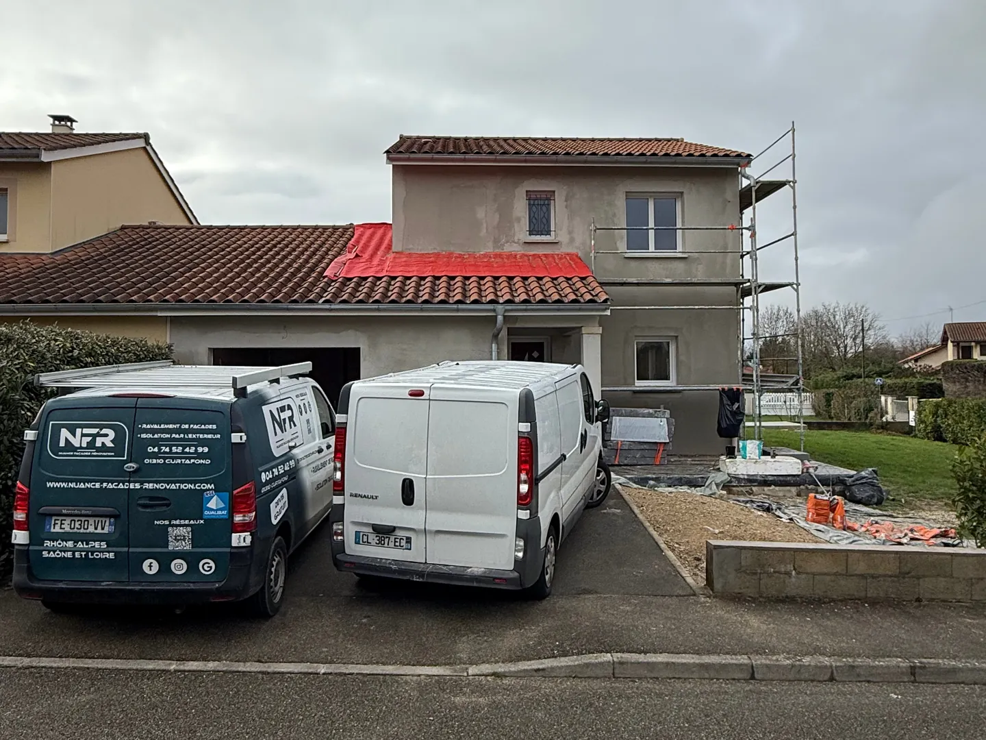 Camionnettes NFR devant la maison sous échafaudage à Ceyzériat